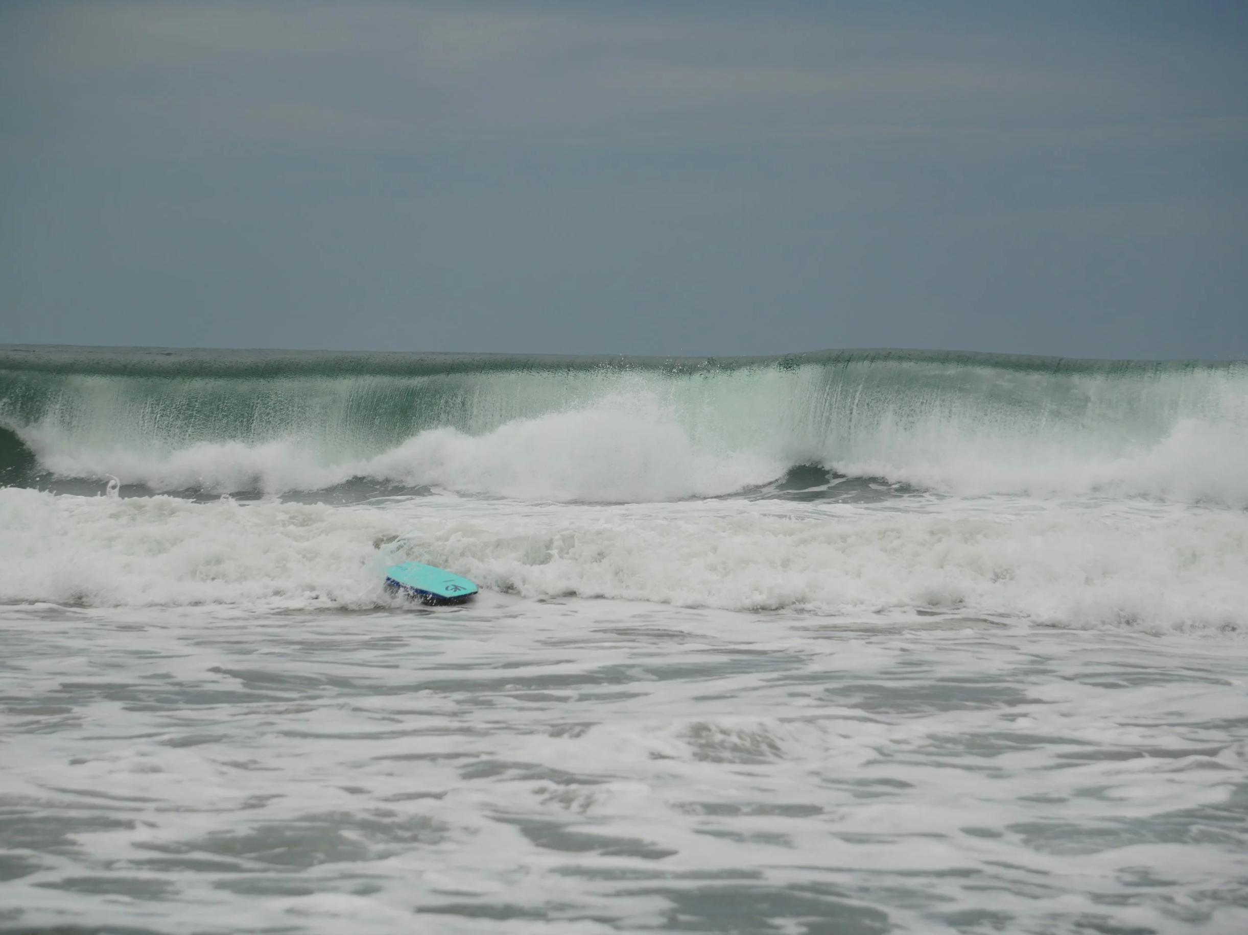 Surfboard floating in rough ocean waves along the Caribbean coast of Costa Rica, showing the raw energy of the sea.