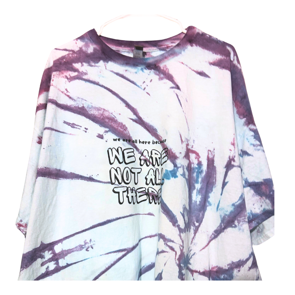 Tie-dye T-shirt with purple, blue, and white swirls and the text "We are not all there" printed on it.