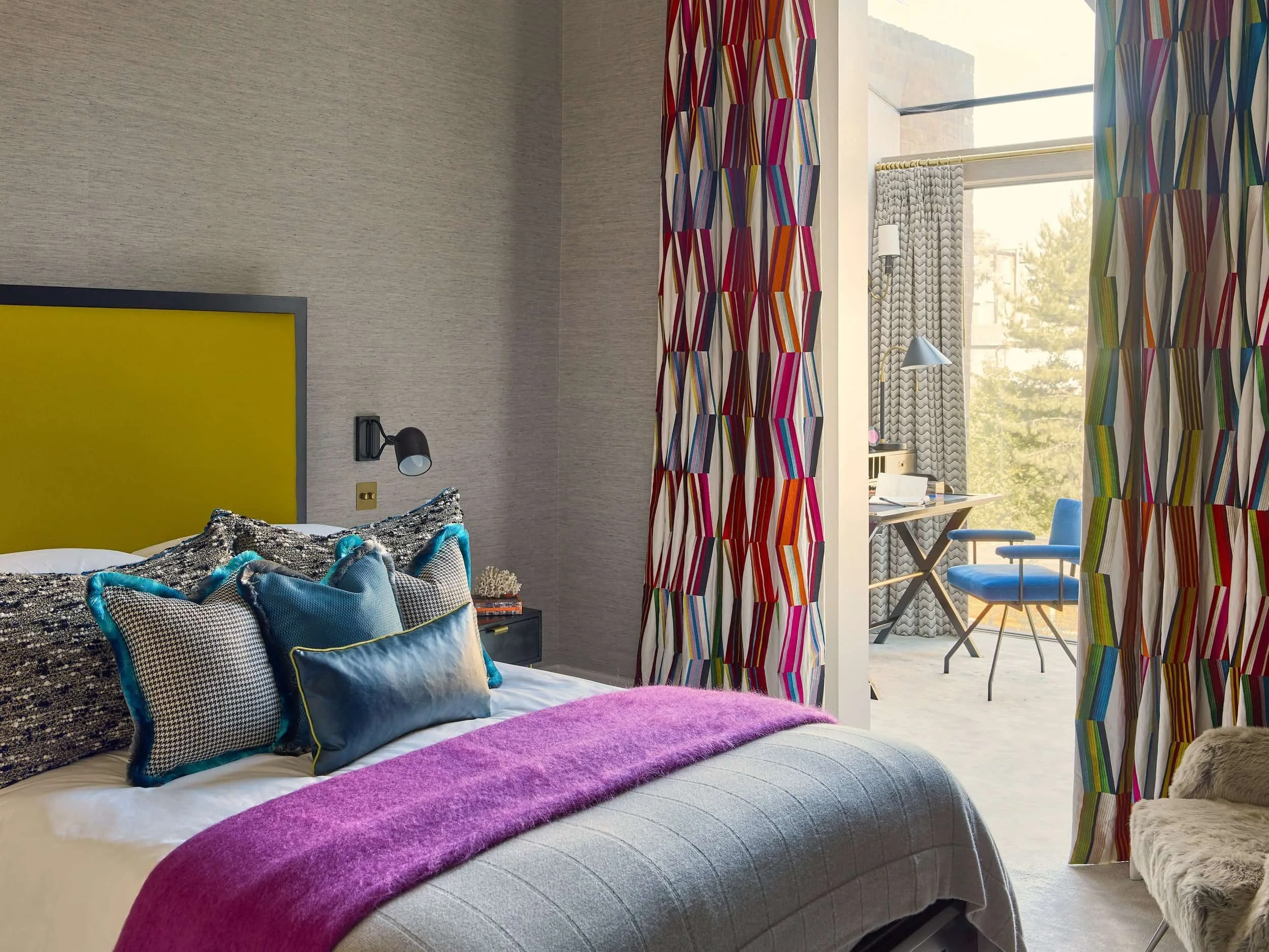 Guest bedroom at Leinster Square with blue cushions, magenta throw and textured wallcovering