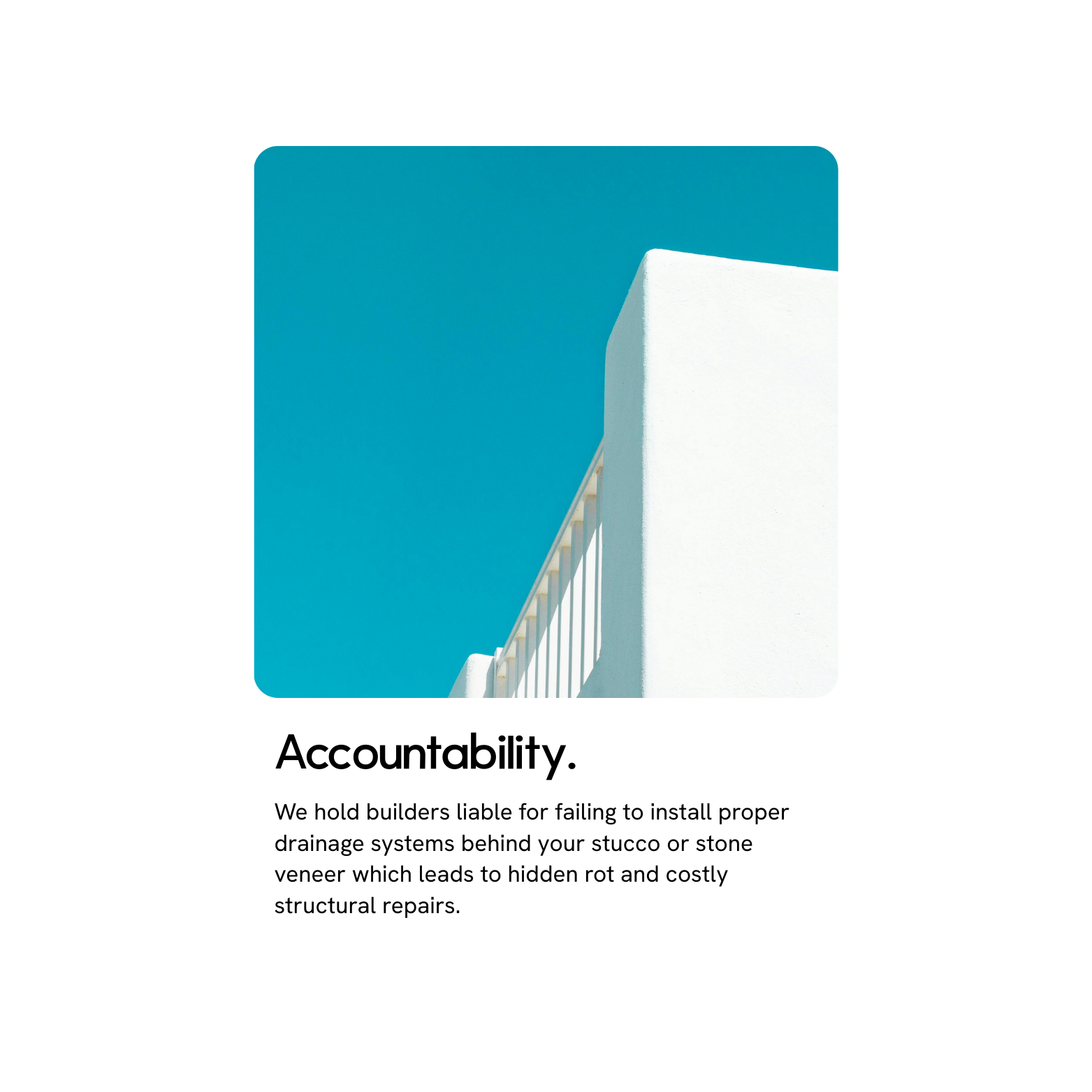 Photograph of a white wall with a blue sky in the background.