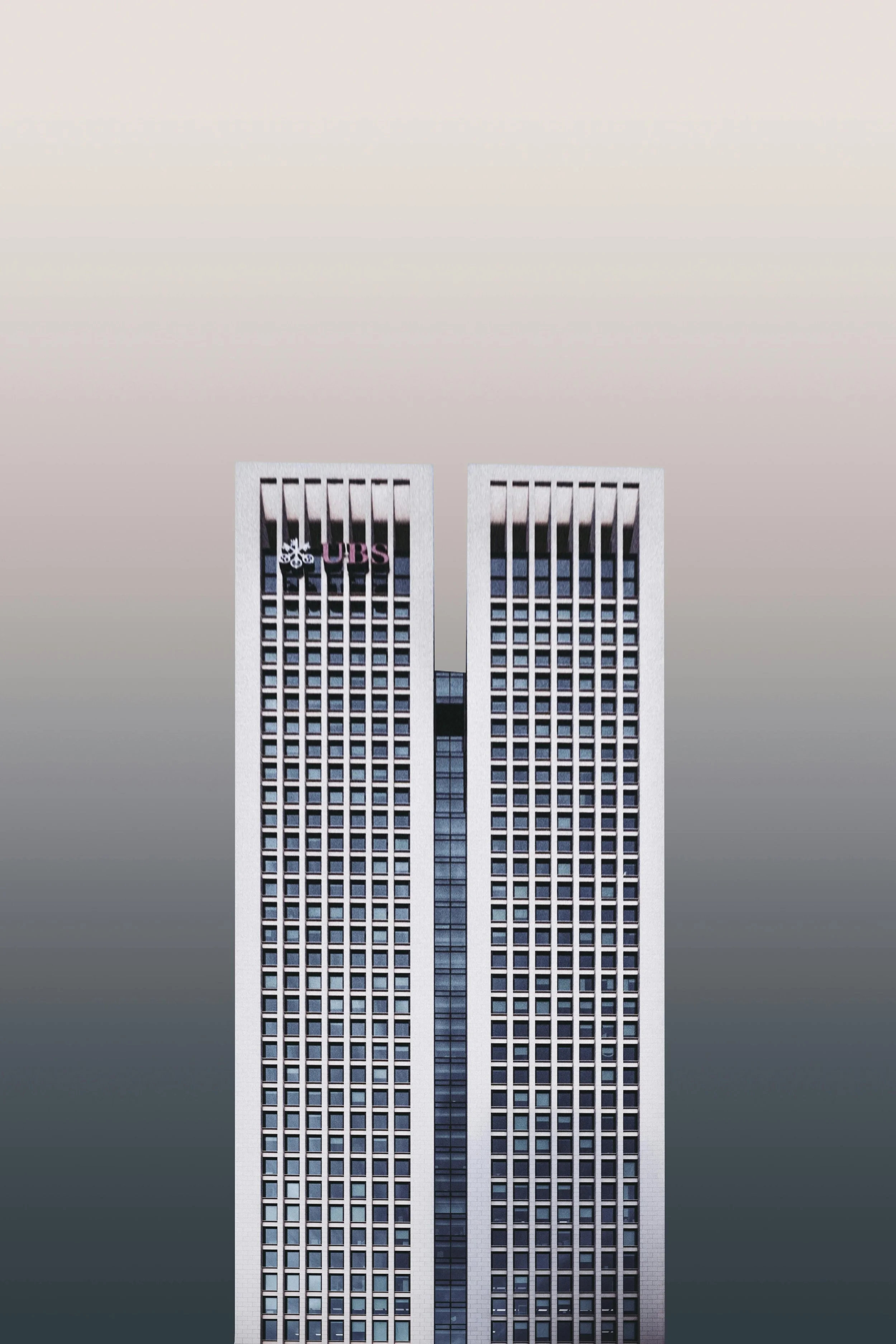 A tall, modern high-rise building with two towers connected by a central section, featuring a grid of windows and a logo at the top of the left tower.