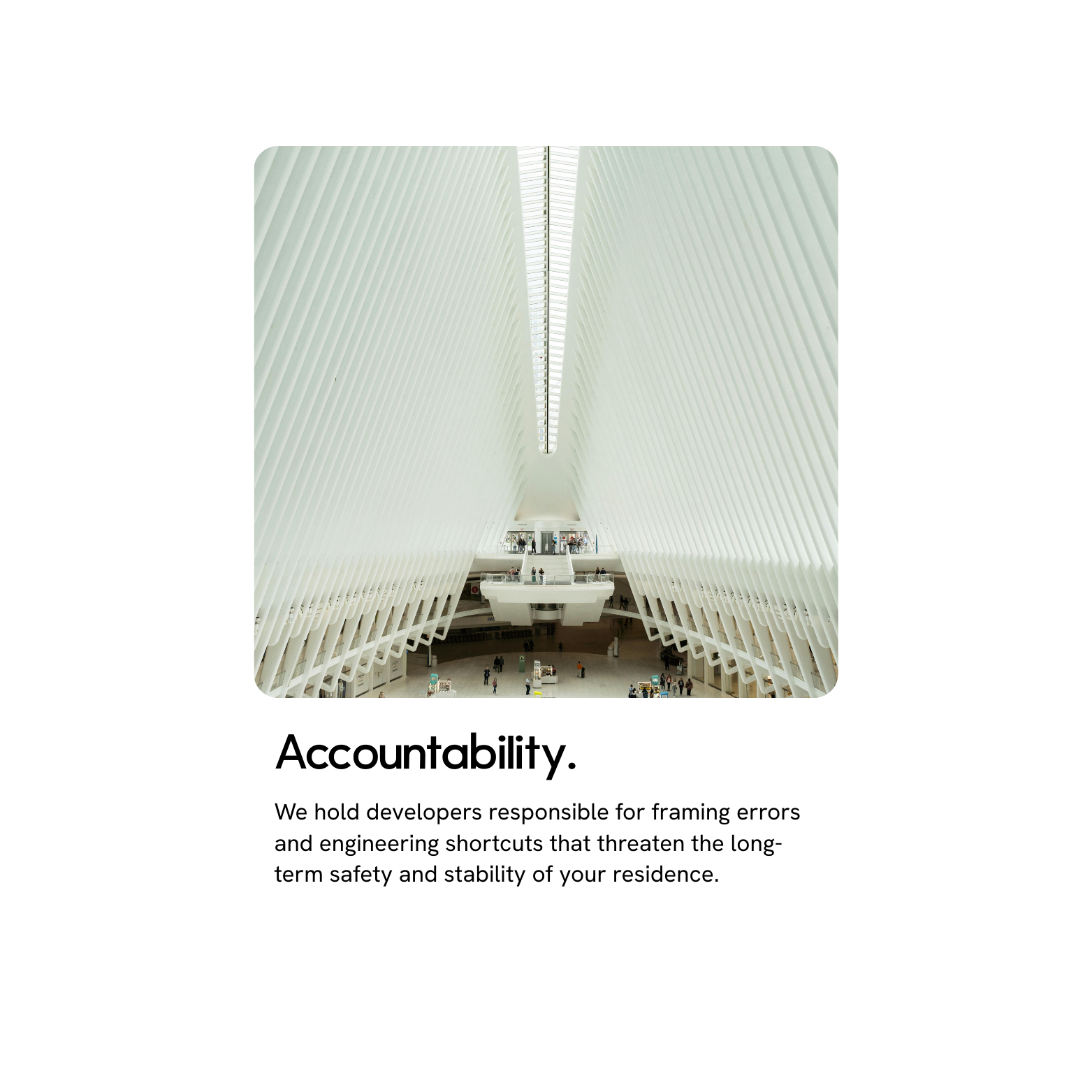 Photo of the interior of a modern architectural building featuring white ribbed walls and high ceilings, with people on both levels.