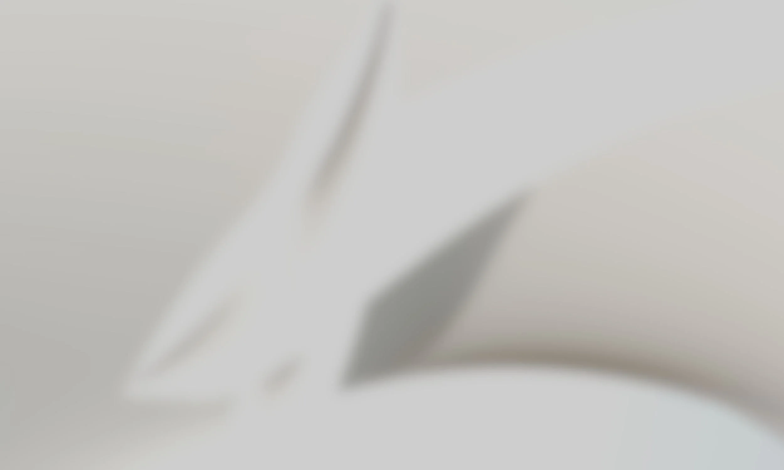 Close-up of a knife blade with a sharp edge, resting on a white surface.