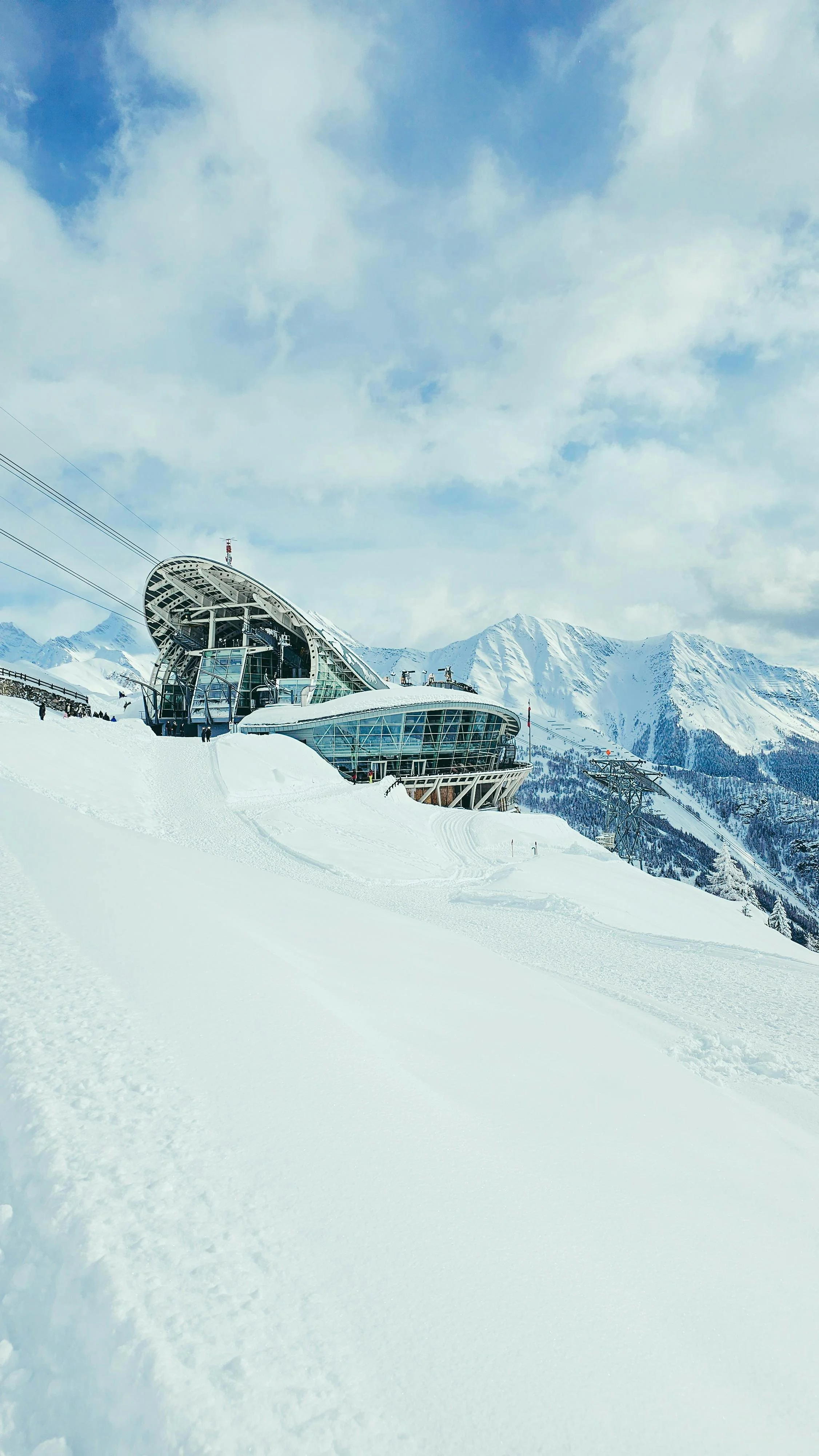 Modern ski resort building with glass walls and snow-covered surroundings at a snowy mountain ski area.