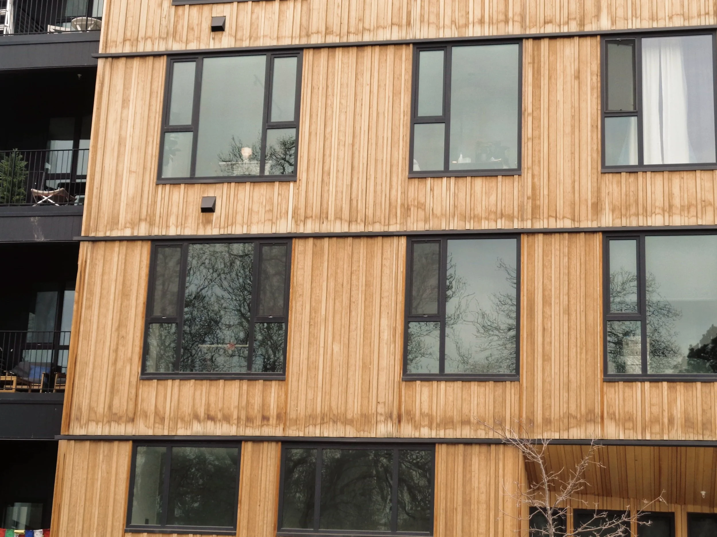A modern apartment building with exterior water damage.