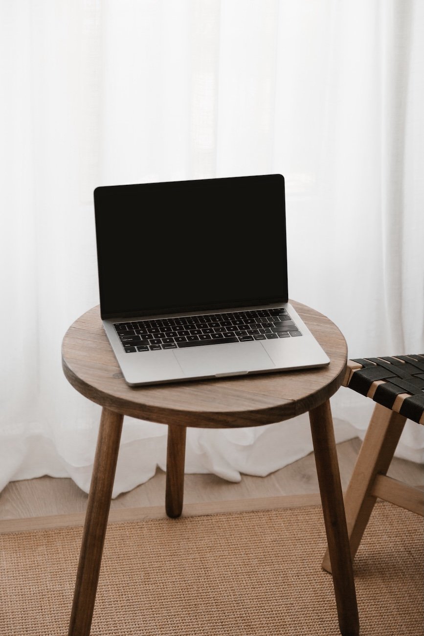 open laptop on wooden stool