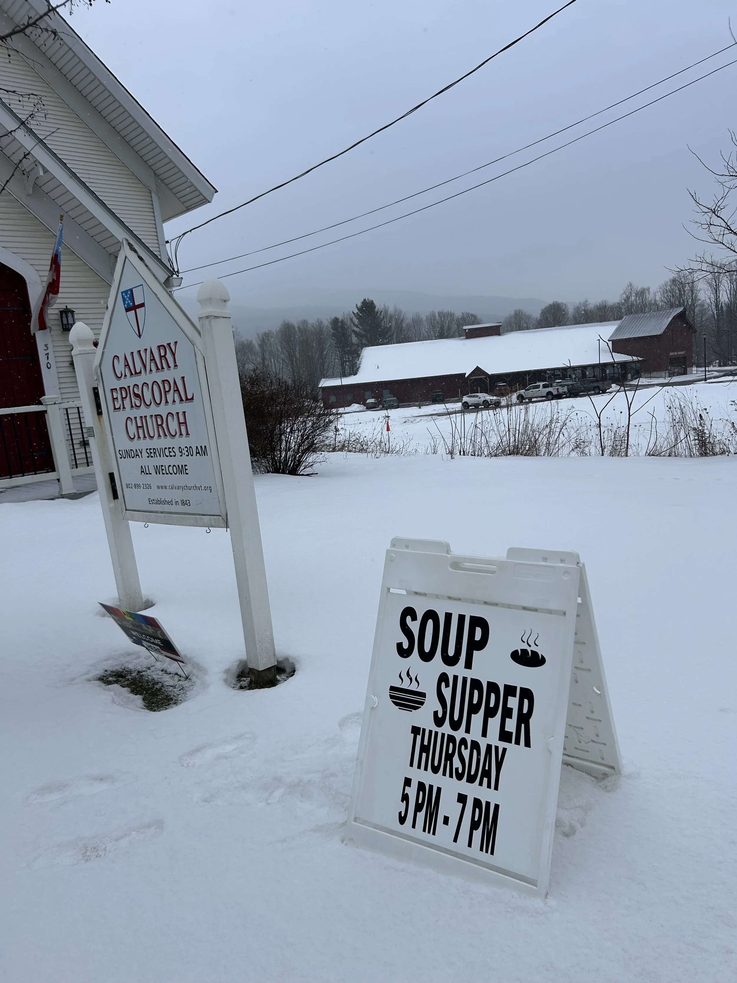 Snowy scene with sandwich board sign in front of Calvary Church reading "Soup Supper Thursday 5PM-7PM."