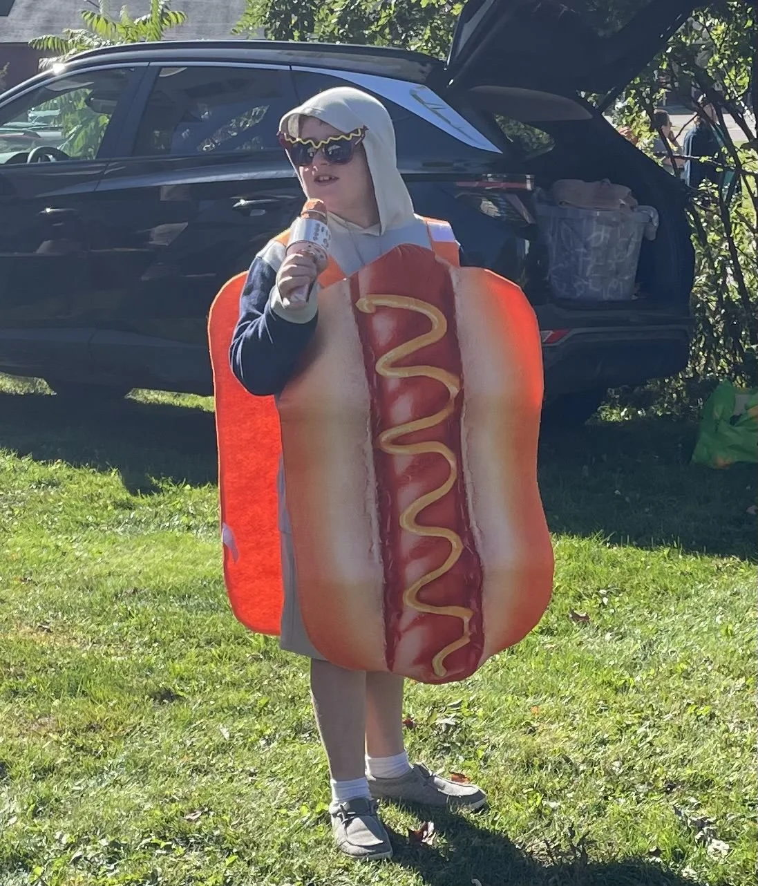 Boy dressed in hotdog costume to draw customers to the Calvary hot dog, sausage and peppers stand.