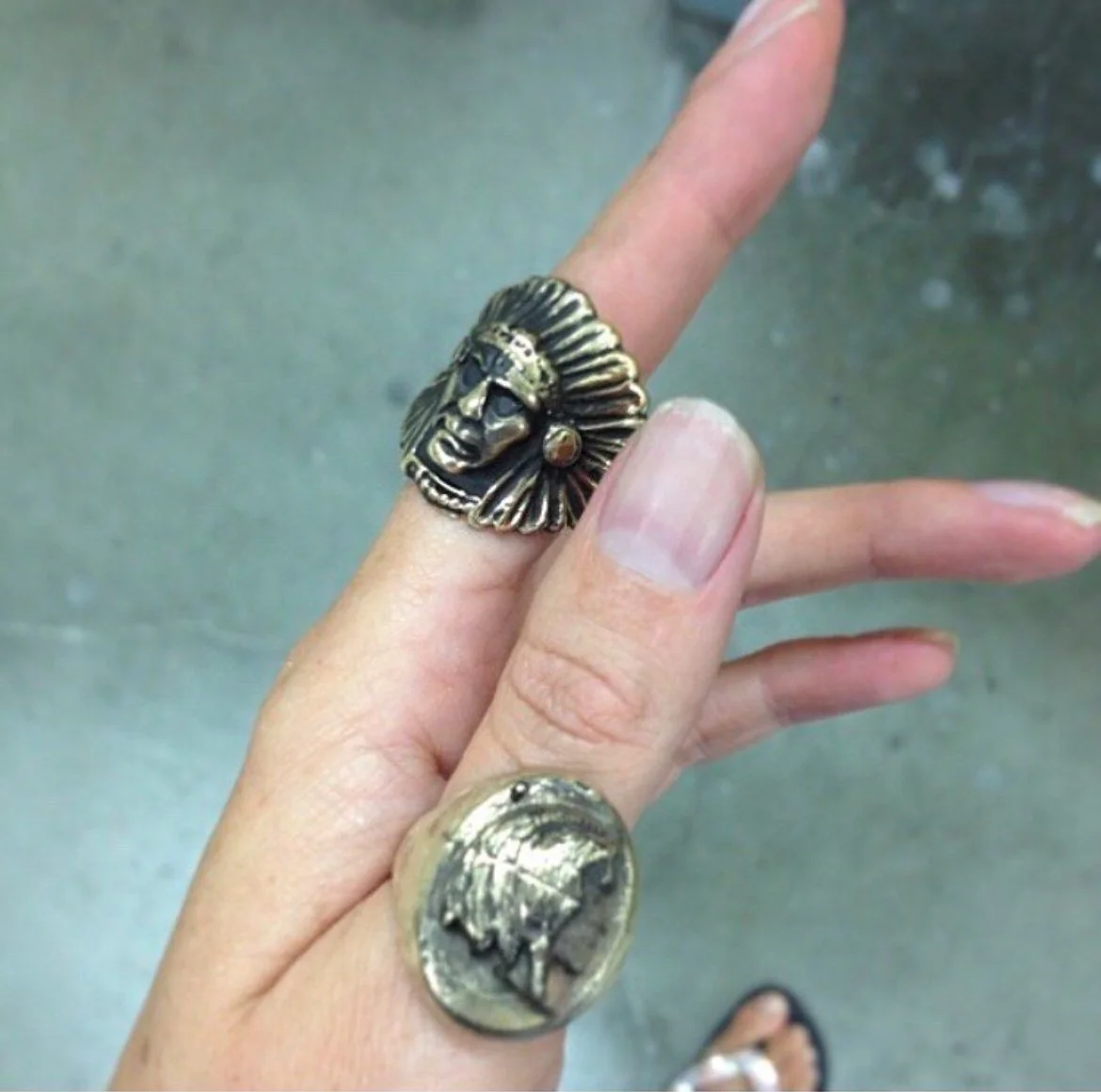 A hand with two rings: hand cast in bronze, native american heads.