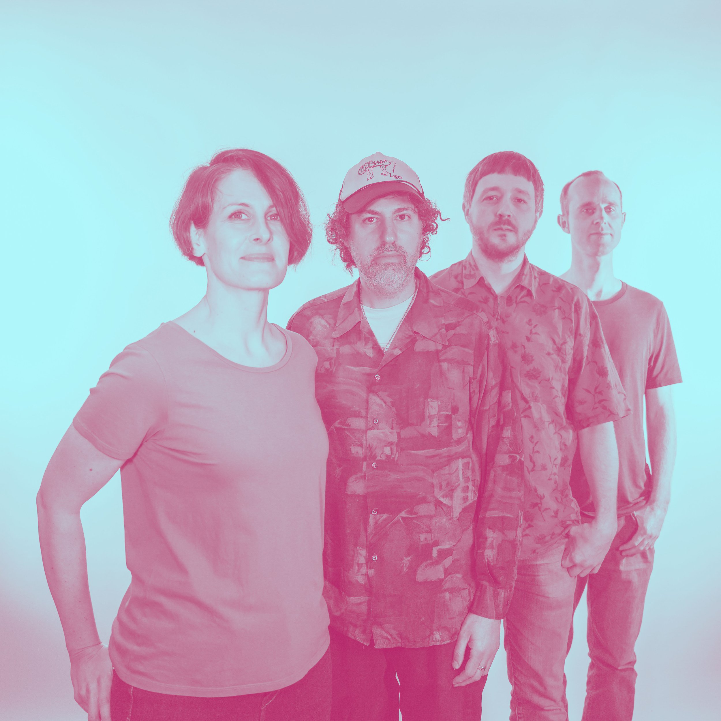 Group of four people standing in a line, facing the camera, against a light background.