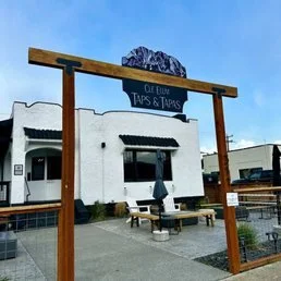 Neon sign for Mike's Tavern with green background and white text against a blue sky.