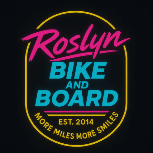 Neon sign displaying 'Roslyn Bike and Board', EST. 2014, with the slogan 'More Miles More Smiles'.