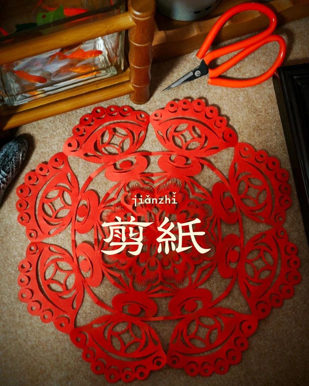 Chinese paper cutting, known as jiǎnzhǐ (剪纸), is an ancient folk art with roots stretching back over 2,000 years. Practitioners use scissors or knives to intricately cut designs from colored paper, creating delicate silhouettes that range from simple