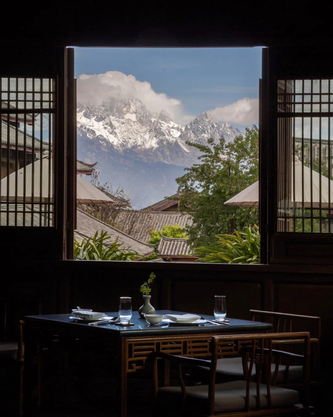 Perched atop Lion Hill above Lijiang's UNESCO-listed Old Town, Amandayan is rooted in the vernacular architecture of the Naxi, the ethnic group that has lived in Lijiang for centuries. Timber structures, stone courtyards, carved screens, and layered 