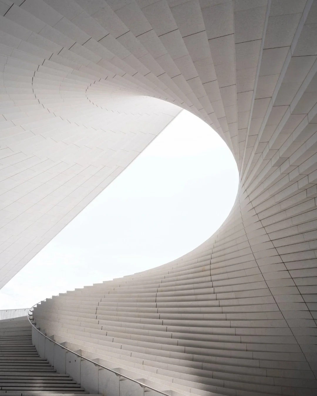 Shanghai Grand Opera House rests along the Huangpu River waterfront within Expo Culture Park, a landmark performing arts complex shaped by two verified core design inspirations: traditional Zh&eacute; Sh&agrave;n 折扇 Chinese folding fan and the flowin
