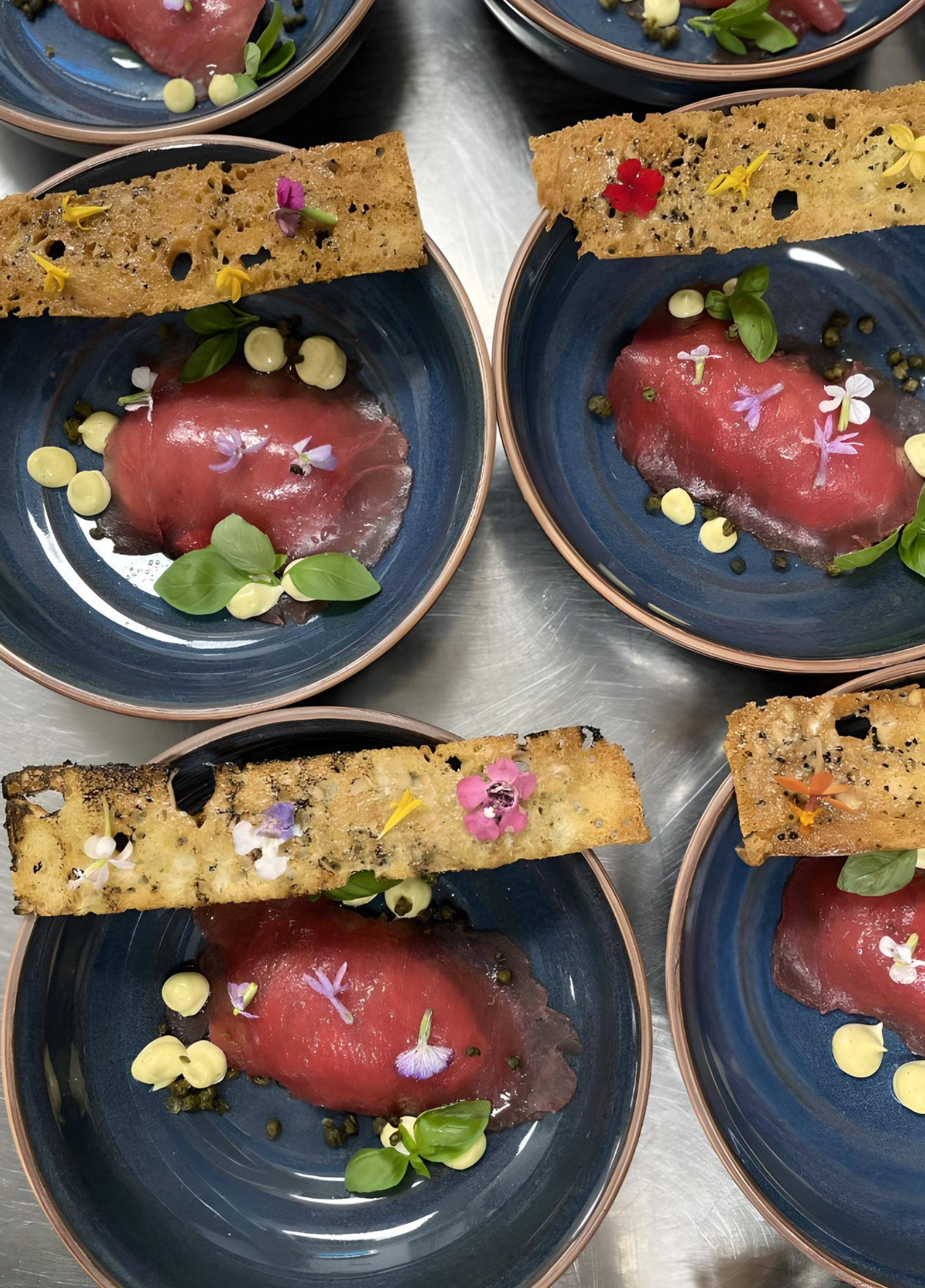 Vitelle Tonnato- Tuna Sashimi, Veal Carpaccio, Big Eye Tuna Mouse, Topped with Fried Capers and Lemon Aioli. Served with 