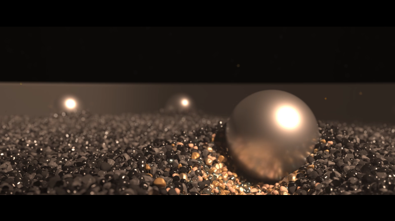 Close-up of three silver spheres on a textured metallic surface with a dark background.