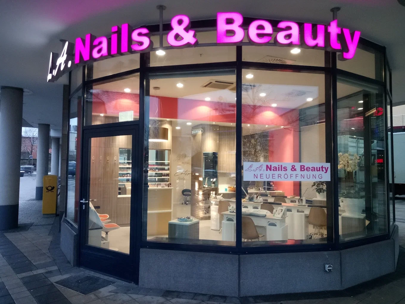 Geschäft mit leuchtendem Schriftzug 'Nails & Beauty', das frisch eröffnet wurde, mit großen Fenstern, die den Innenraum mit Nagelpflege- und Schönheitsprodukten zeigen.