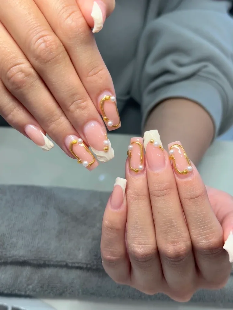 Nägel mit weißem French-Tip und goldenen, perlgefüllten Nagelringen