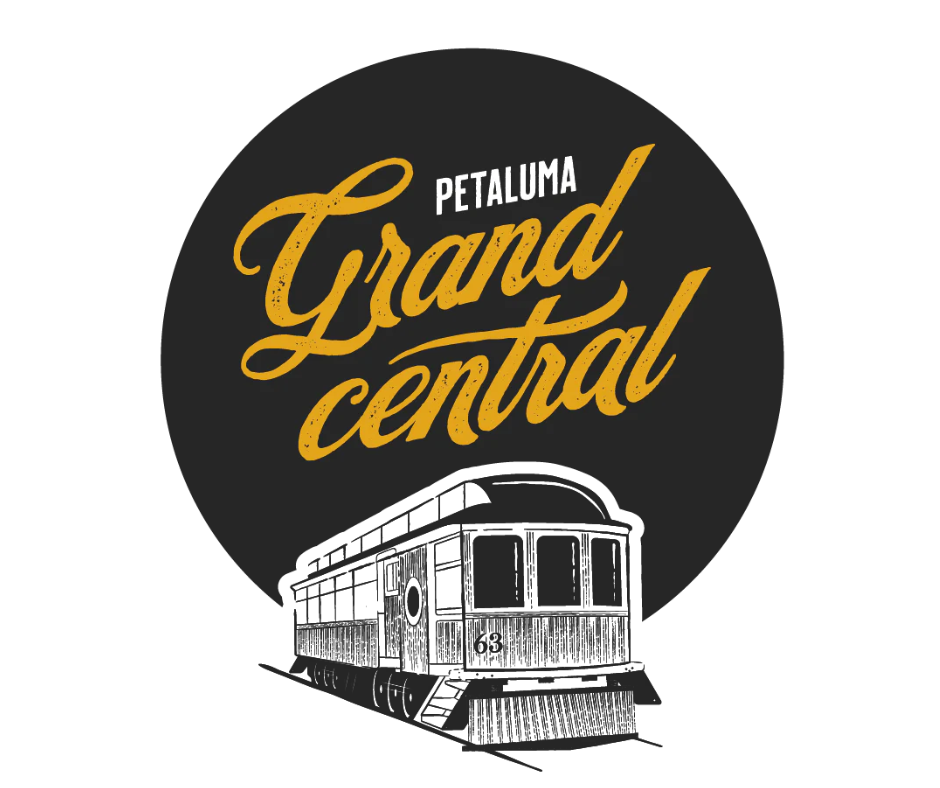 Graphic logo with a black circle background featuring a vintage tram and the text "Petaluma Grand Central" in gold cursive font.