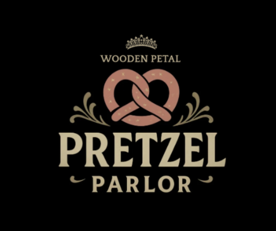 Logo for Wooden Petal Pretzel Parlor with a pretzel graphic, a crown, and decorative flourishes on a black background.