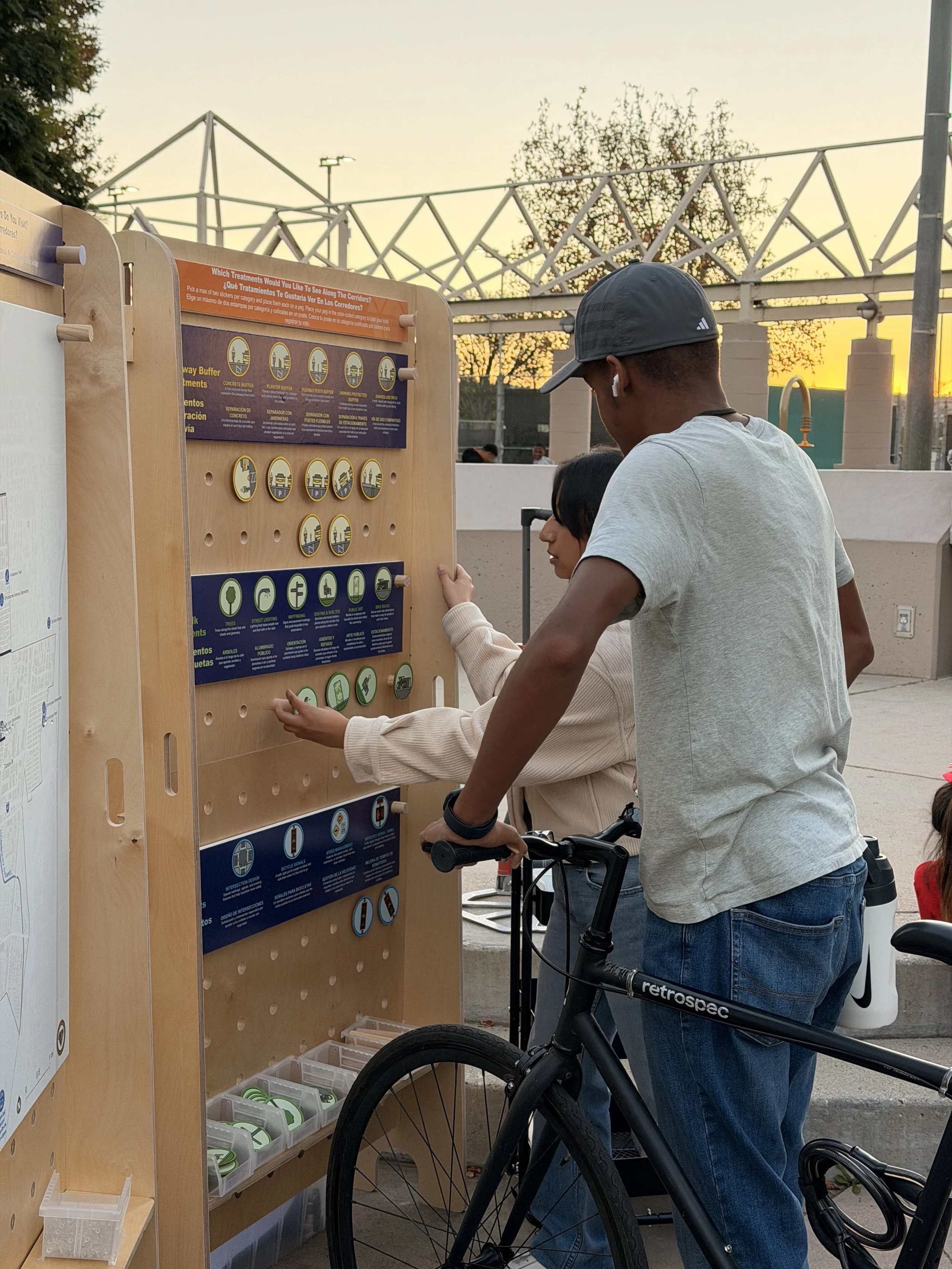 Child on bicycle looking at an outreach board
