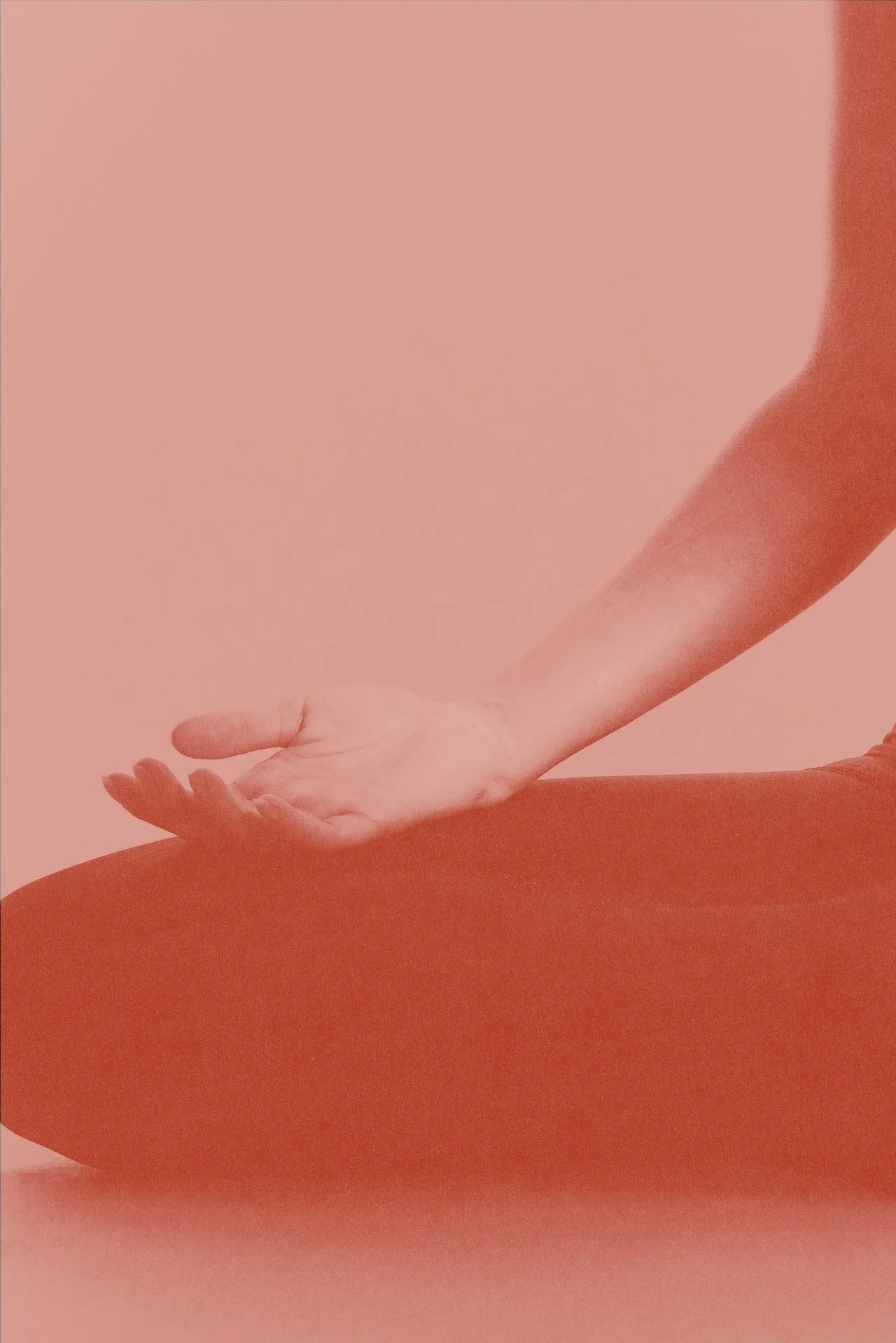 Close-up of a person doing a yoga pose, focusing on the arm and hand resting on the knee, with a pink background.