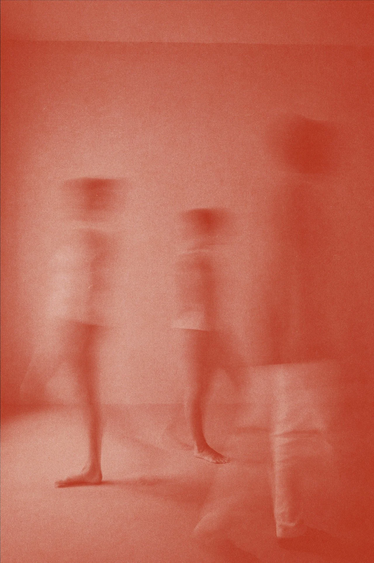 Three women in bikinis walking in a line with a blurred, reddish filter on the image.