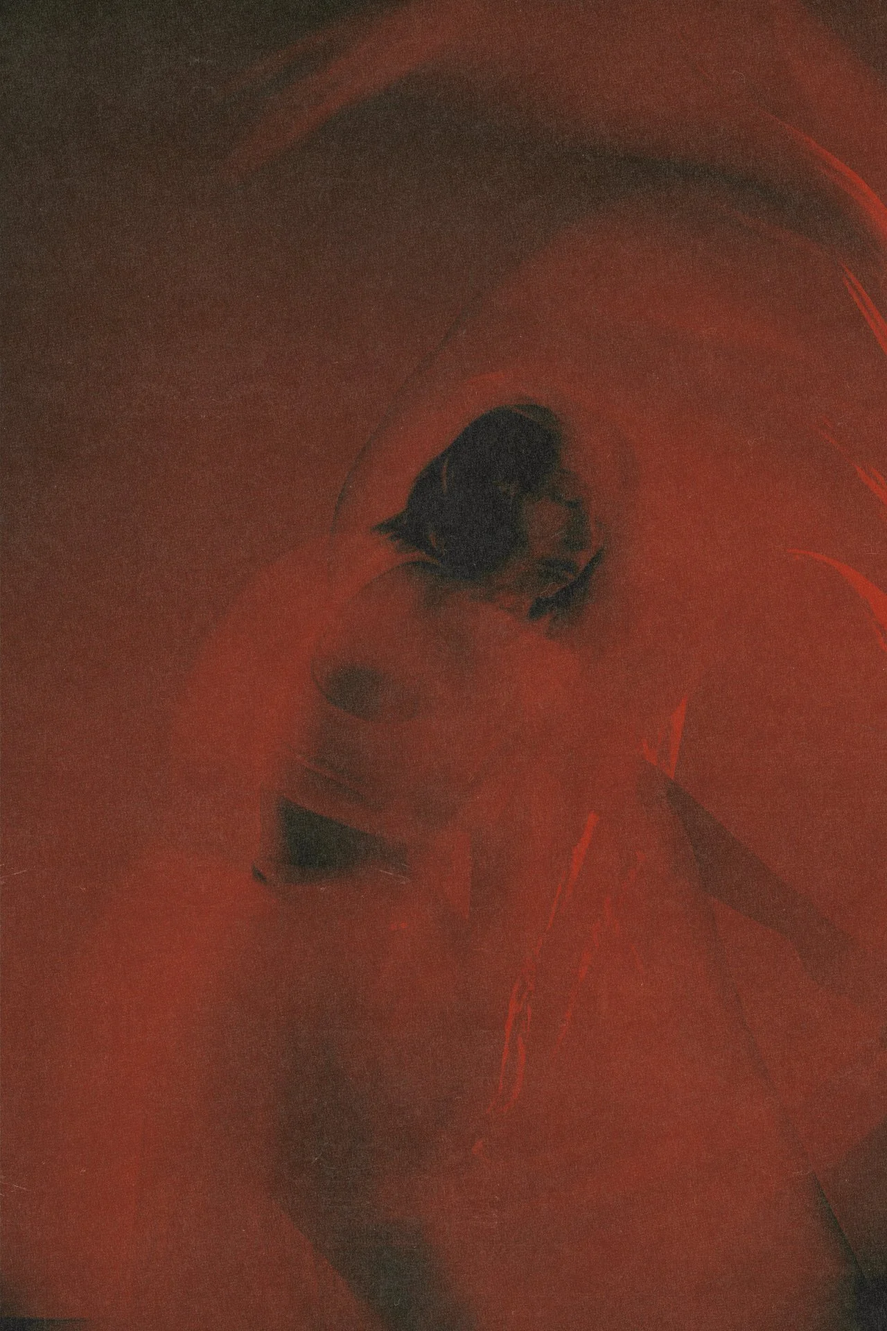 Close-up of a person's face distinguished by artistic, dark, and red tones with an abstract appearance.