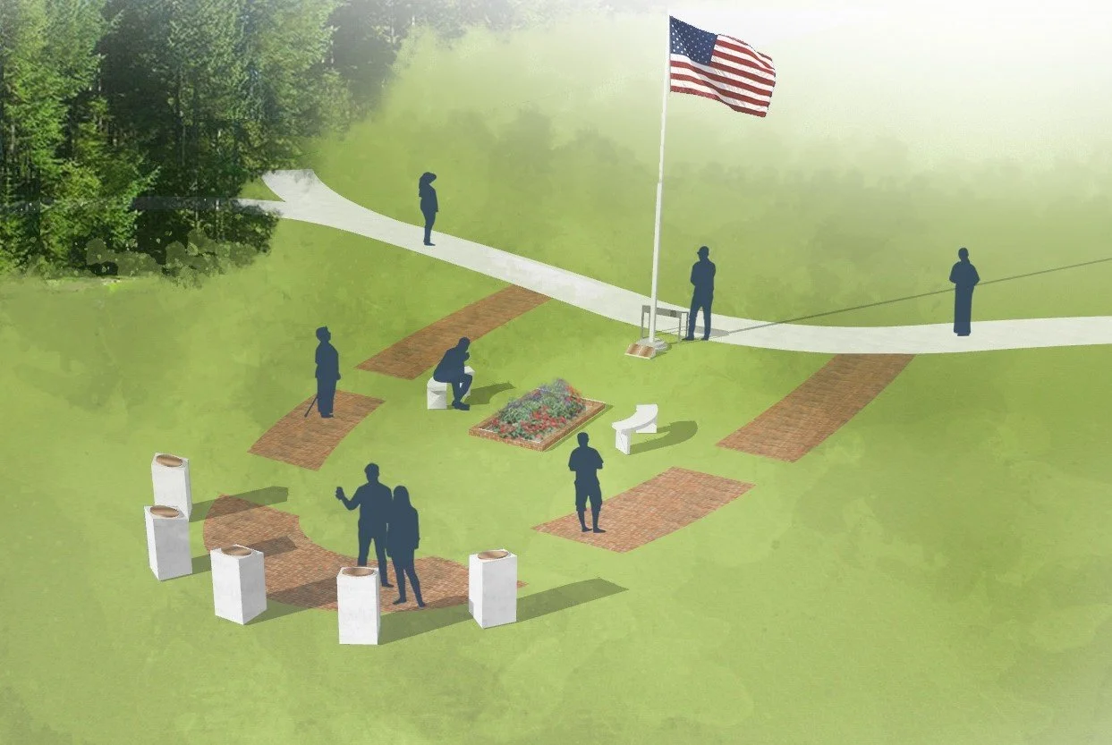 A memorial site with a flagpole and American flag surrounded by people, benches, trash cans, and brick pathways in a green park area.