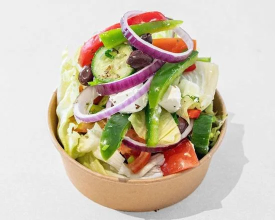 A bowl of fresh vegetable salad with lettuce, tomatoes, cucumbers, black olives, red onions, and bell peppers.