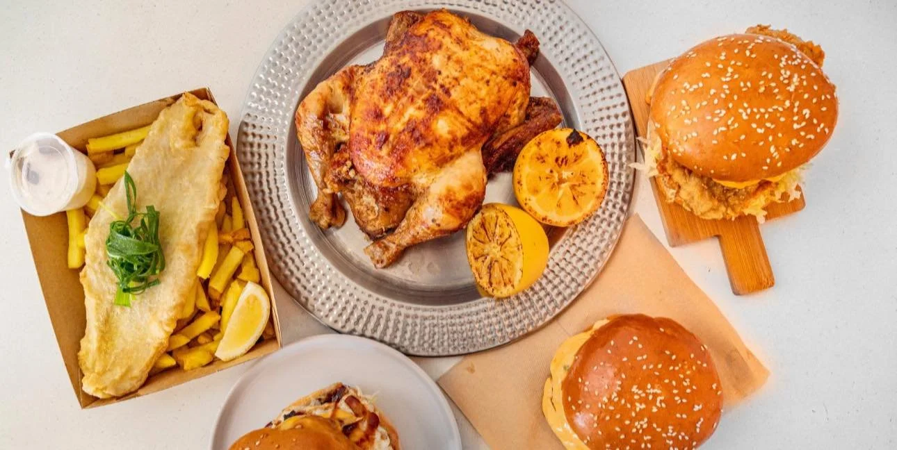 Fried fish with French fries, lemon wedge, and tartar sauce; roasted chicken with grilled lemon slices; two cheeseburgers with sesame seed buns, lettuce, and fried chicken sandwich.