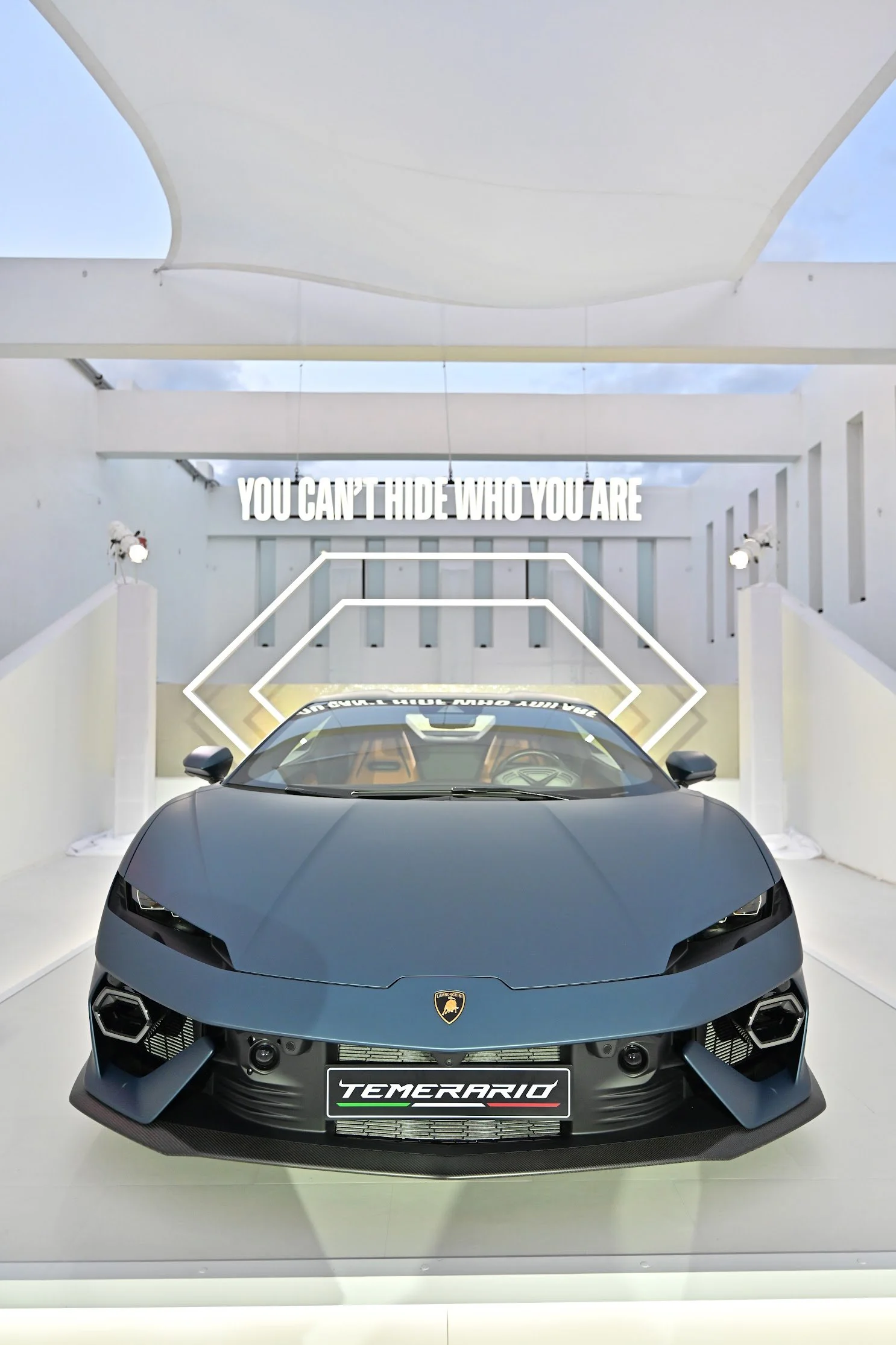 Front view of a matte black Lamborghini Lamborghini Huracan Templar at an auto show with a white background, signage, and lighting.