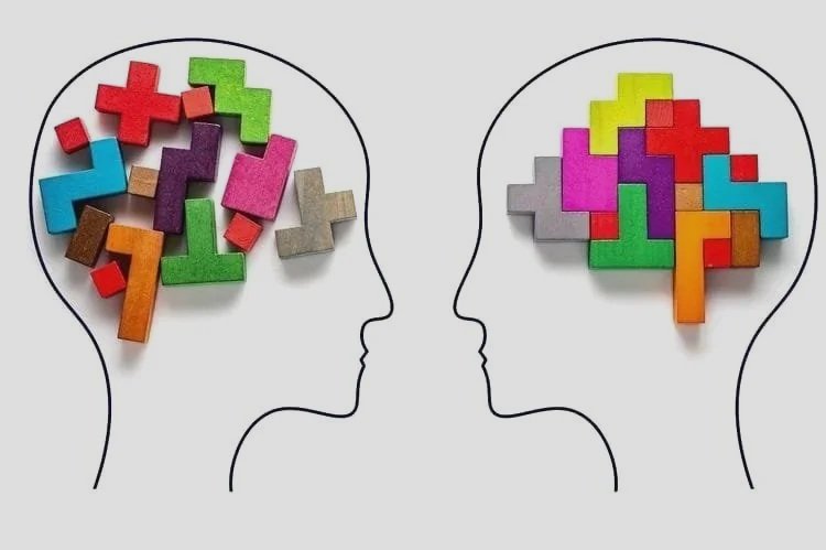 Zwei Silhouetten von Köpfen, in denen bunte Puzzles und Holzbausteine als Gedanken- oder Gehirnvisualisierung angeordnet sind.