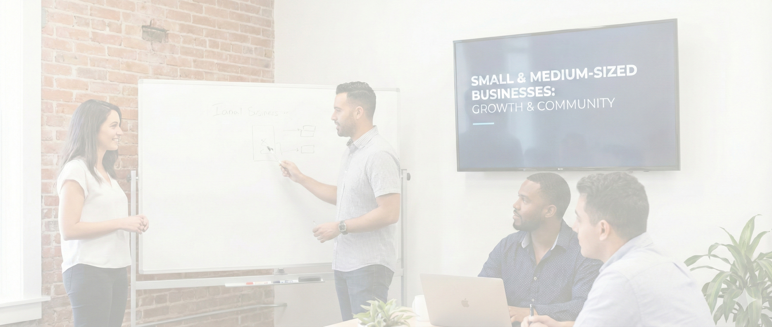 A diverse group of people in a business meeting room with a whiteboard and a large screen that reads "Small & Medium-Sized Businesses: Growth & Community." A man is presenting, and two other men are paying attention, with laptops open in front of them.