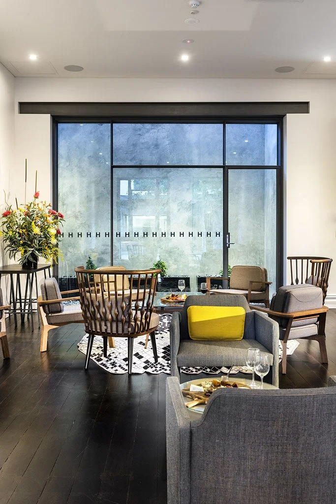 Modern indoor lounge area with various chairs and a large window.