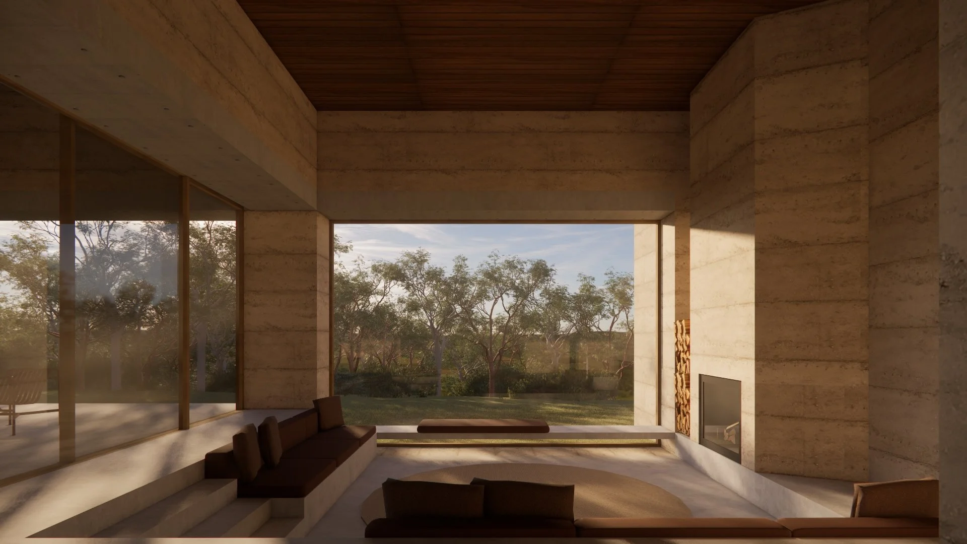 Modern living room with large windows, stone walls, and a view of trees outside. Interior features a built-in fireplace, brown sofas, and a round rug.