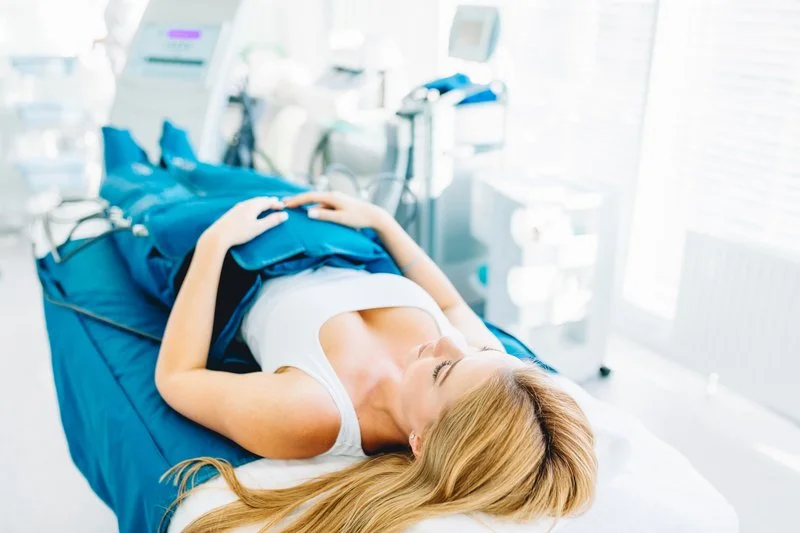 A woman lying on a hospital bed in a medical setting.