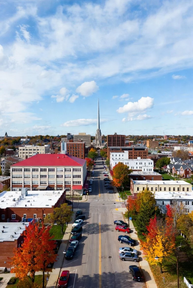 Silhouette of a city skyline with tall buildings and a sunset in the background.