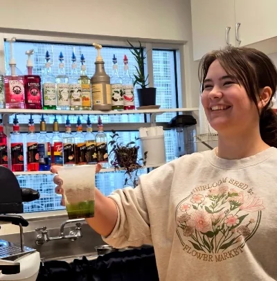 Barista handing drink to customer at Pit Stop Cafe