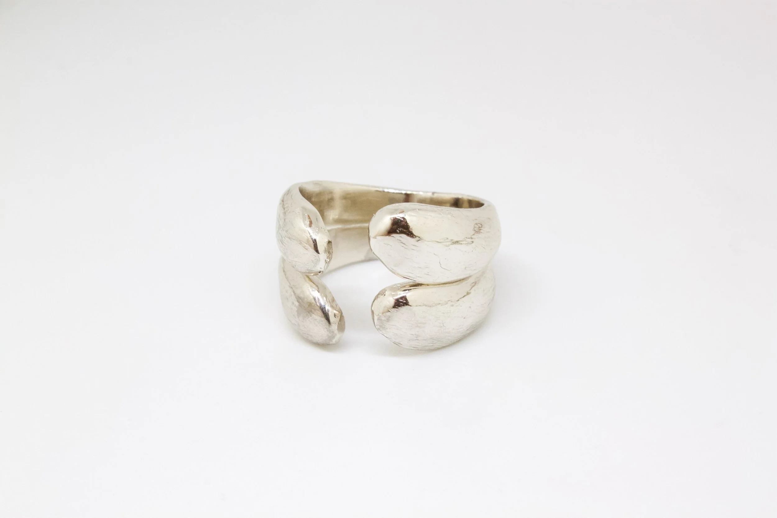 Silver ring with a chunky, abstract design on a white background.