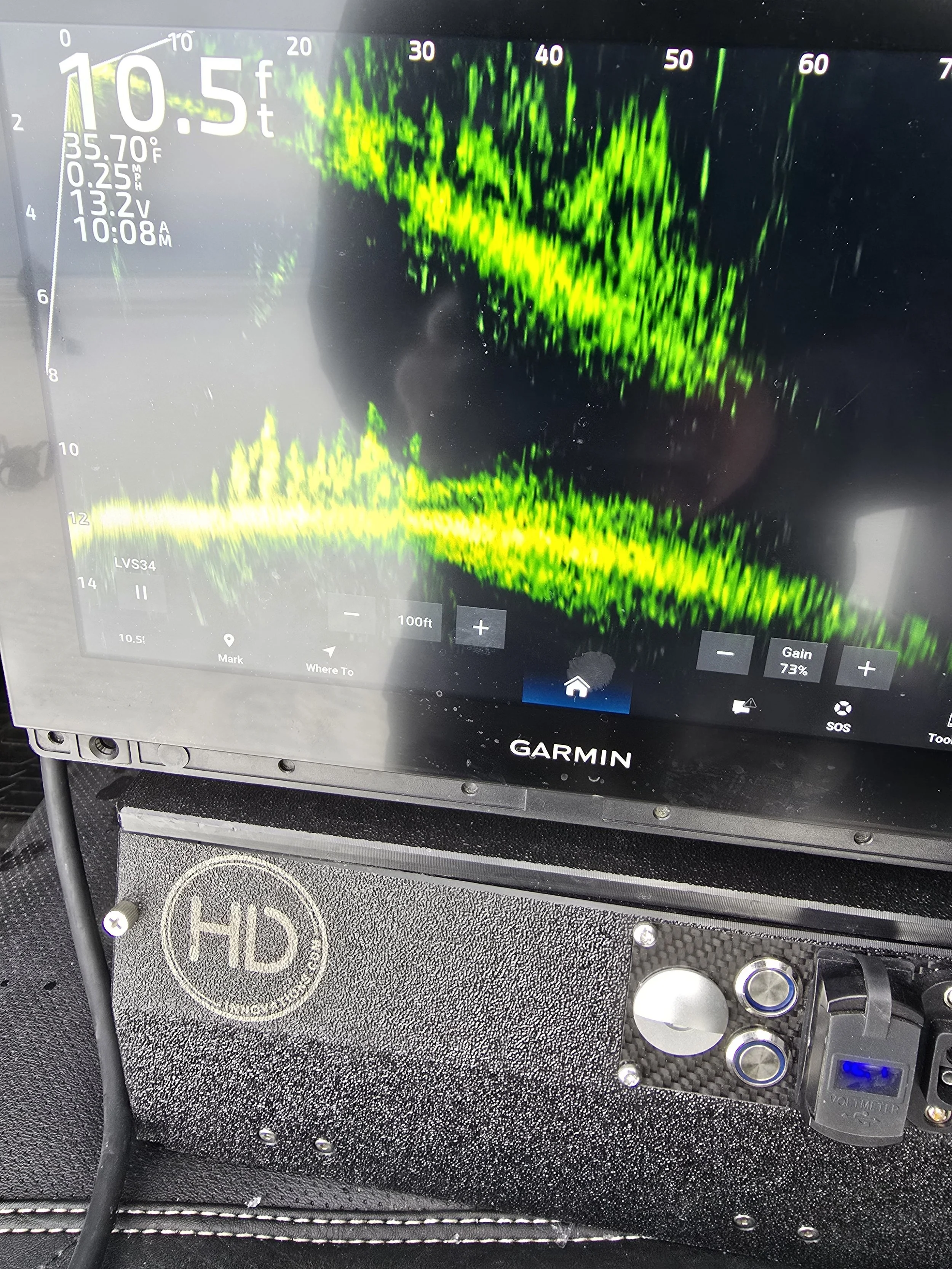 A Garmin fish finder screen showing water depth of 10.5 feet, temperature 35.7°F, and other sonar readings in green and yellow, with a black background.
