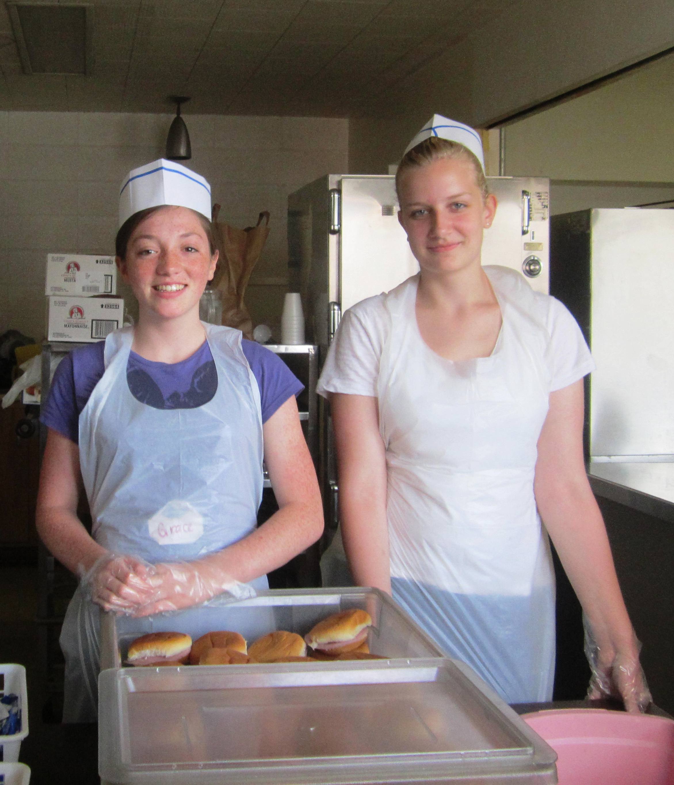 Grace and Morgana hand out sandwiches in the serving line