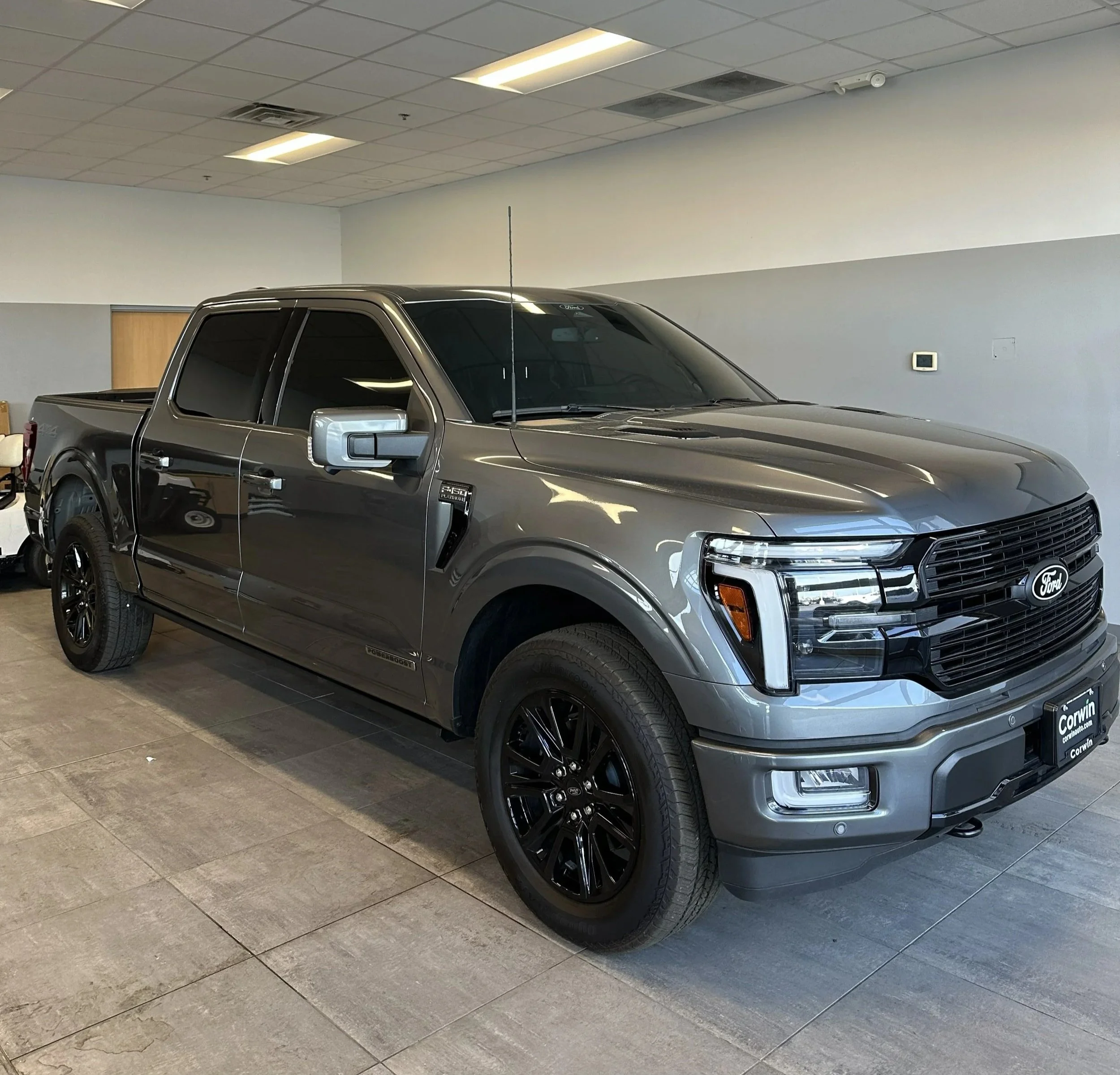 A gray Ford F-150 pickup truck parked indoors with black wheels and tinted windows.