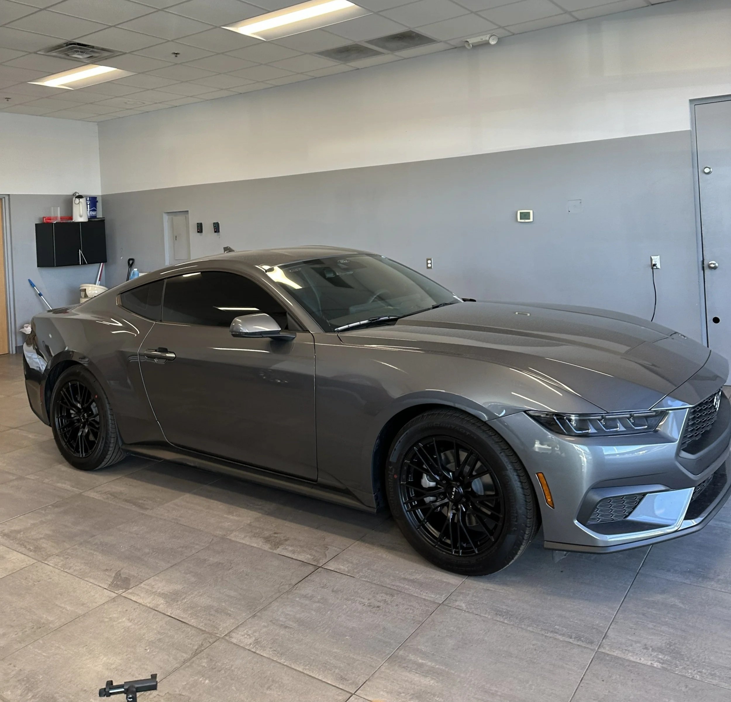 A Ford Mustang Parked inside a shop With Tinted Windows 