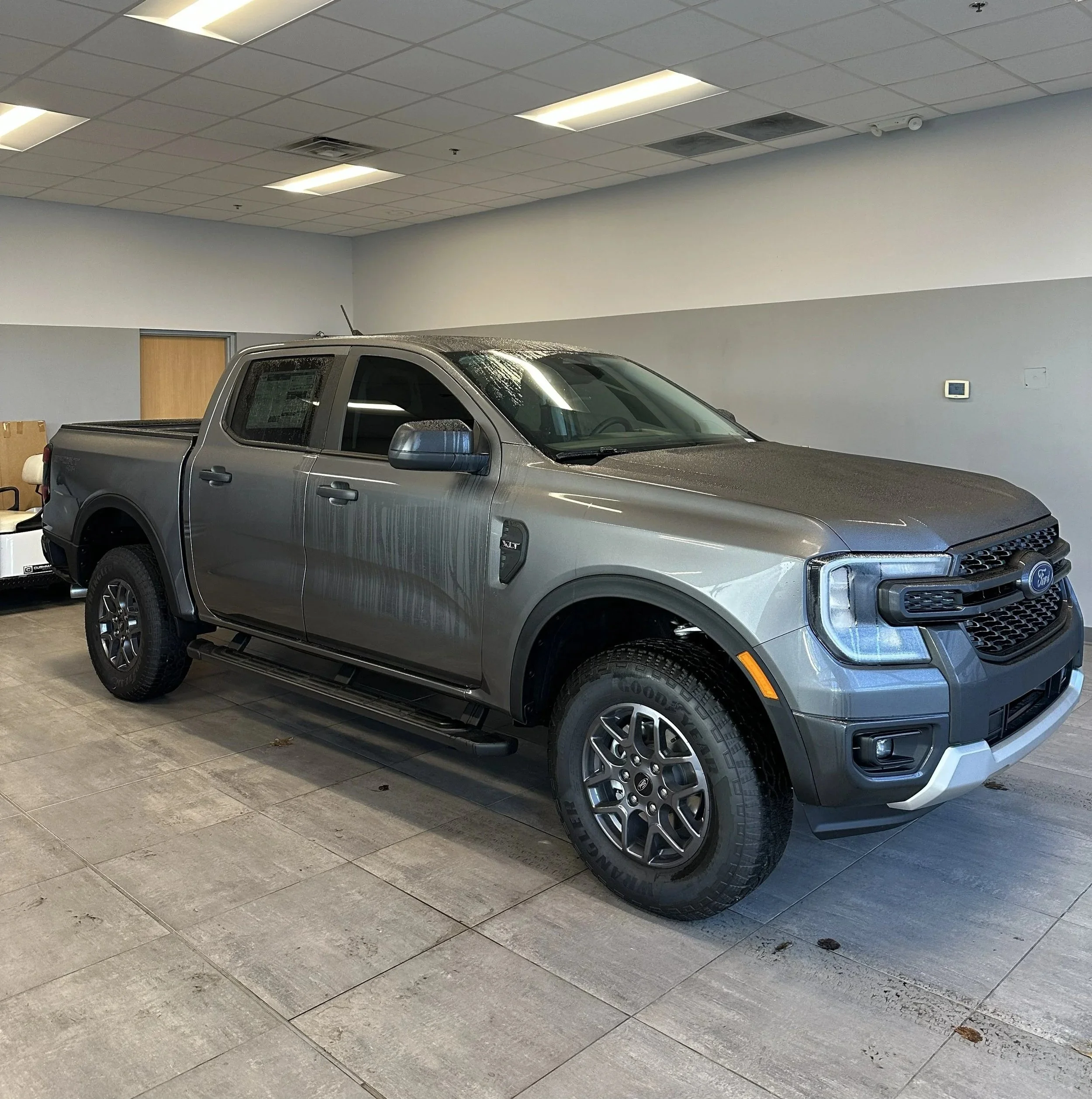 A silver Ford pickup truck parked inside the shop and Two Front Windows Tinted to Match Rears.