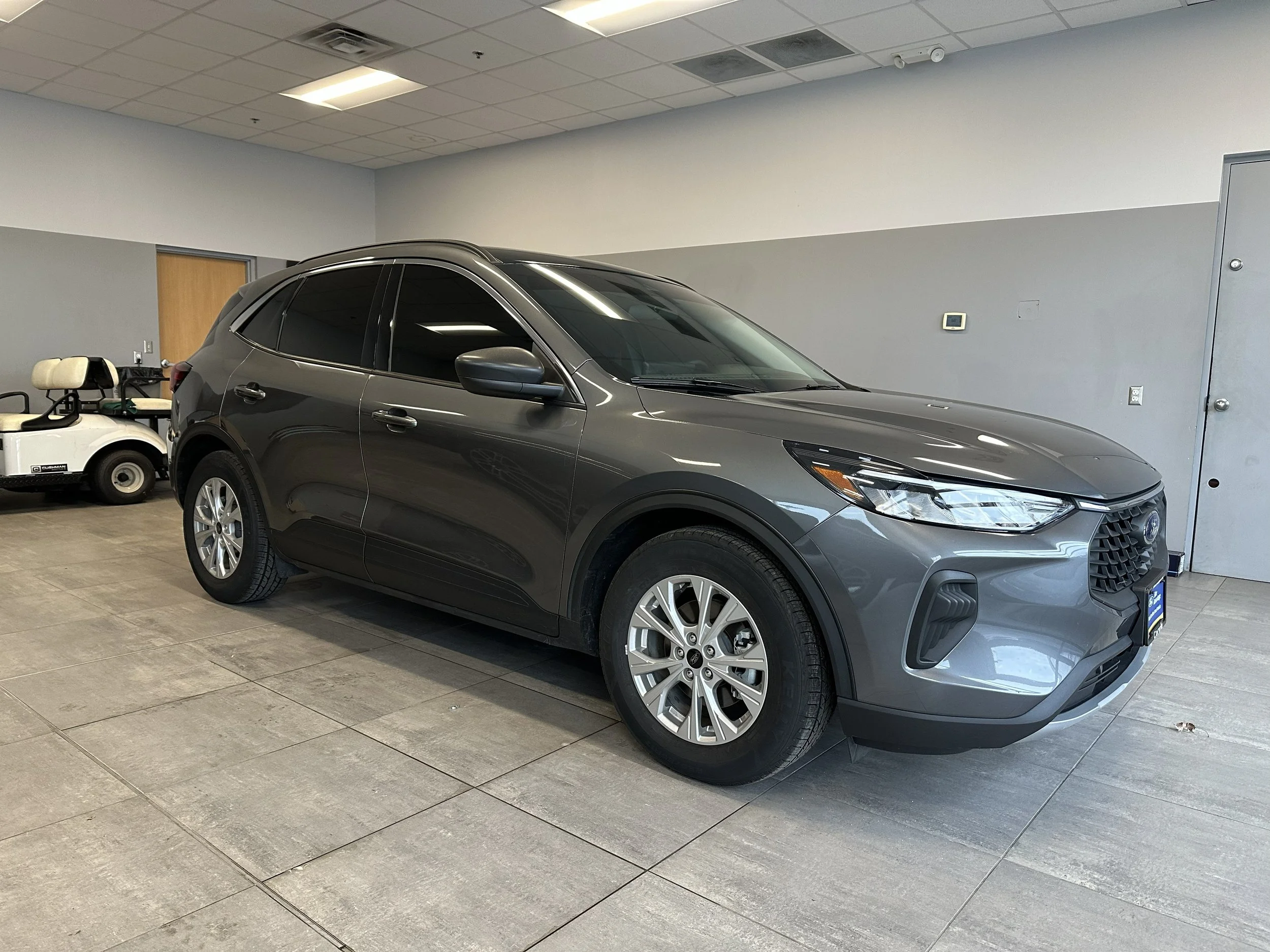 Gray Ford Escape inside the shop with tinted windows.