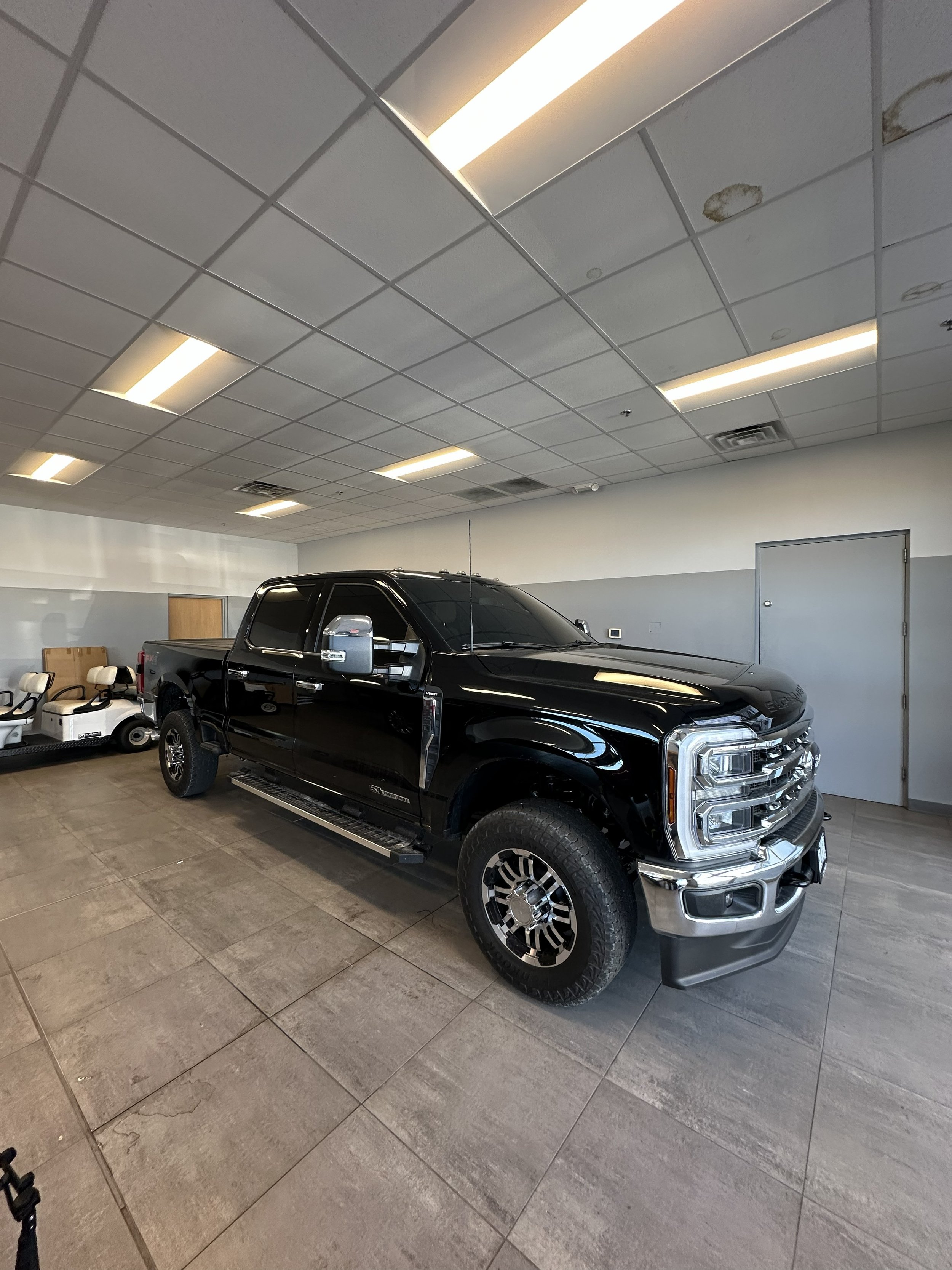 A black pickup truck inside a shop with Tinted Windows 