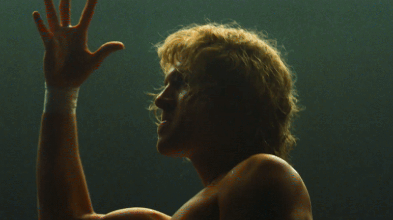 A silhouette of a woman with curly hair raising her hand against a dark background.