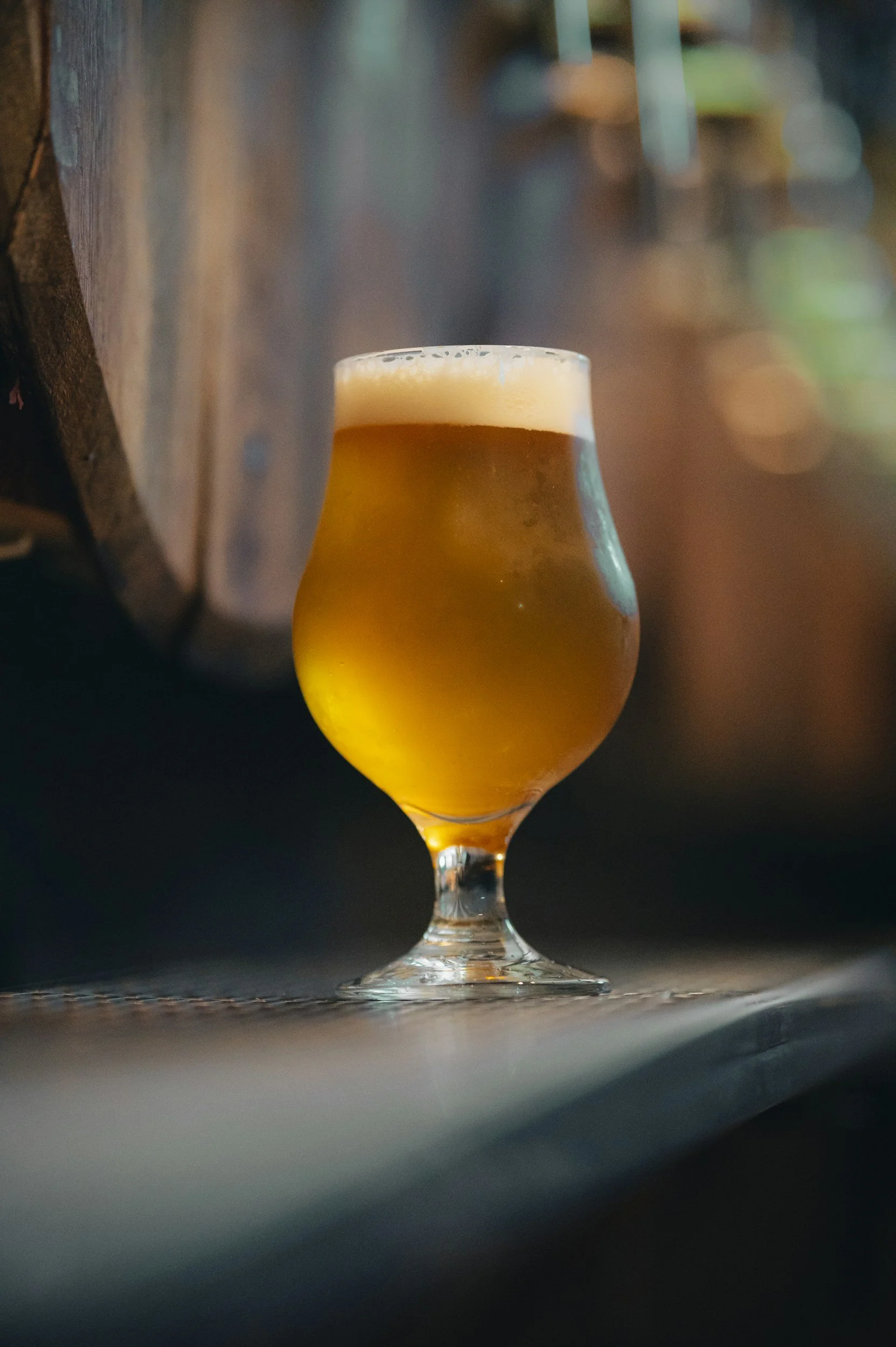 ビールのグラス。木製の背景と暗い環境で置かれている